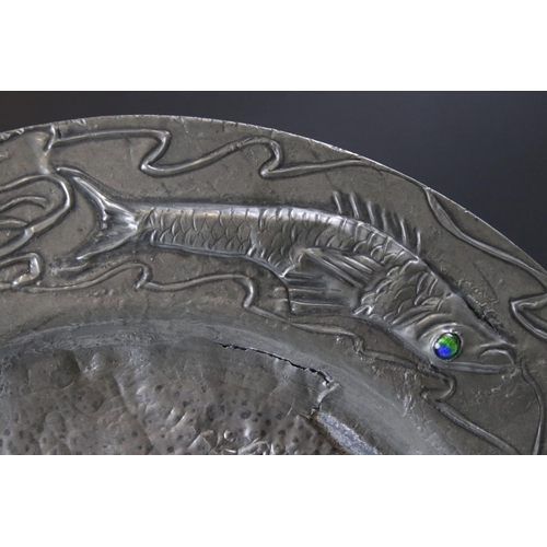 92 - Arts and Crafts Pewter Charger / Plate, the rim with embossed decoration of Four Fish each set with ... 