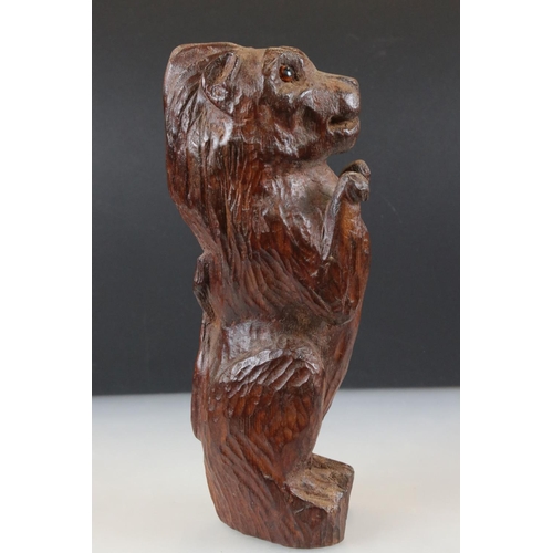 98 - Black Forest style naive carved Lion sitting on his haunches with glass eyes, 33cm high