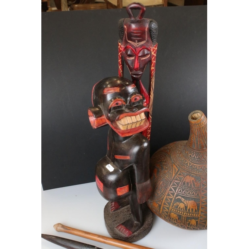 368 - A small collection of carved wooden tribal items to include masks, figures, club and bottle together... 