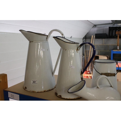 381 - A collection of three graduated white enamel jugs together with two similar pieces.