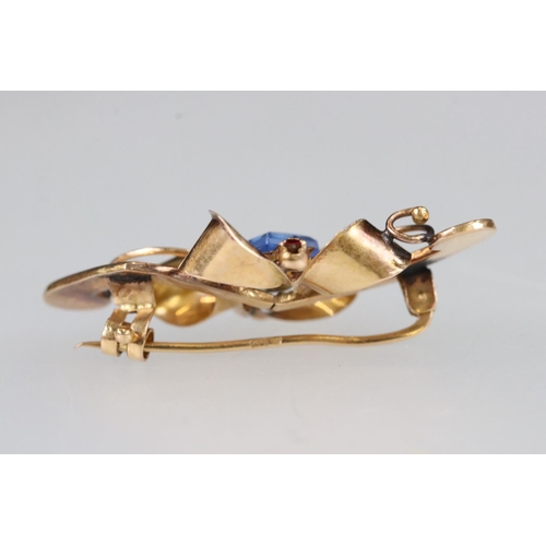 209A - An early 20th century ladies brooch, rose gold in colour and set with blue & red stones, marked 800 ... 