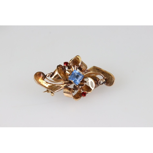 209A - An early 20th century ladies brooch, rose gold in colour and set with blue & red stones, marked 800 ... 