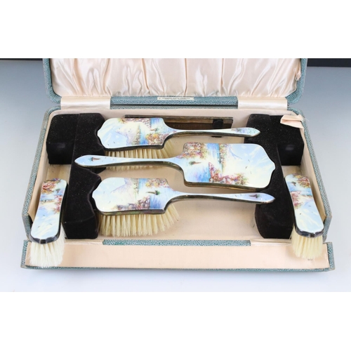 254 - A mid 20th century silver plated brush and mirror vanity set with detailed enamel decoration and con... 