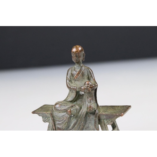 260 - Bronze Buddha in robe, seated in the lotus position, on a bench, approx. 7cm tall