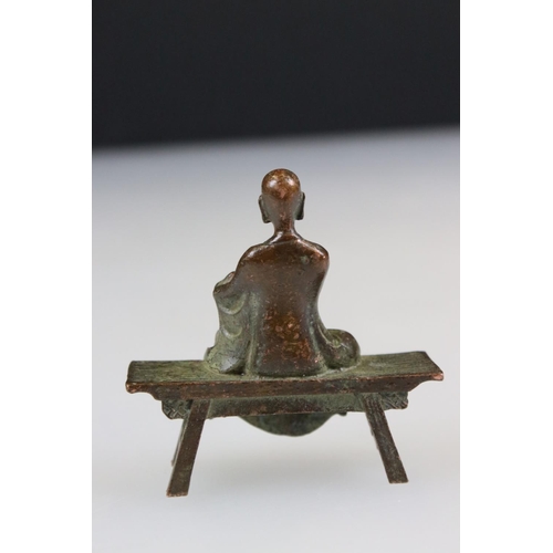 260 - Bronze Buddha in robe, seated in the lotus position, on a bench, approx. 7cm tall