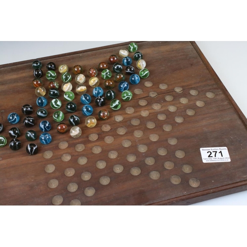 271 - An early to mid 20th century wooden solitaire board together with marbles.