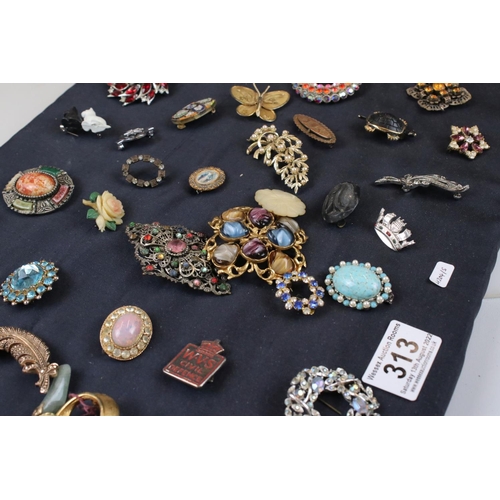 313 - Collection of approx. 73 brooches on a cushioned board, to include silver, micro mosaic & others