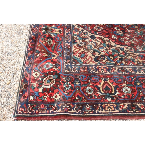 633 - Large Wool Red Ground Rug decorated with geometric floral pattern within a border, 483cm x 417cm