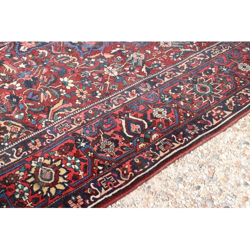 633 - Large Wool Red Ground Rug decorated with geometric floral pattern within a border, 483cm x 417cm