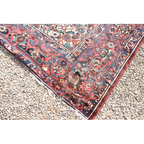 633 - Large Wool Red Ground Rug decorated with geometric floral pattern within a border, 483cm x 417cm