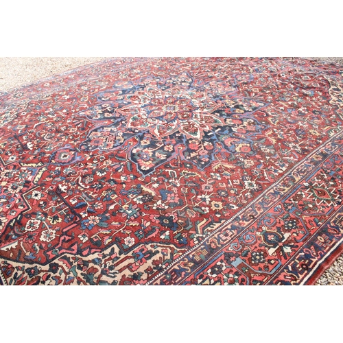 633 - Large Wool Red Ground Rug decorated with geometric floral pattern within a border, 483cm x 417cm