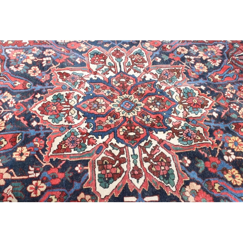 633 - Large Wool Red Ground Rug decorated with geometric floral pattern within a border, 483cm x 417cm