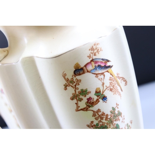 48 - Set of Three Crown Ducal Graduating Blush Ivory Jugs decorated with exotic birds, largest 22cm