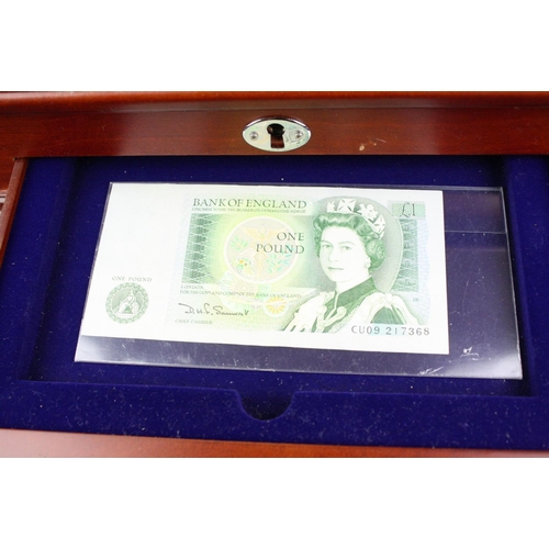 208 - A Danbury Mint 'Her Majesty Queen Elizabeth II' coin and banknote set mounted within wood and glass ... 