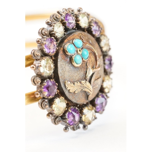 104 - Late Victorian / Edwardian amethyst, citrine and turquoise yellow metal hinged bangle; the central m... 