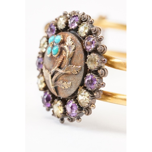 104 - Late Victorian / Edwardian amethyst, citrine and turquoise yellow metal hinged bangle; the central m... 