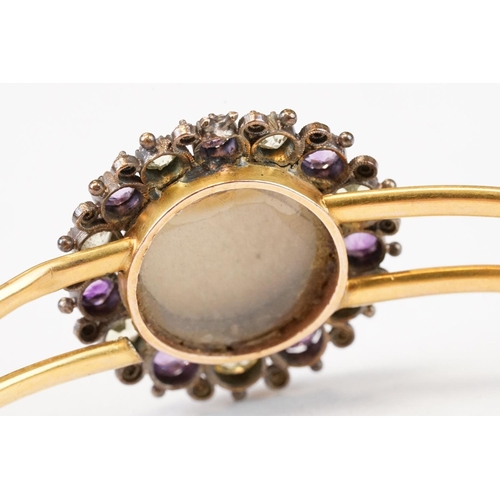 104 - Late Victorian / Edwardian amethyst, citrine and turquoise yellow metal hinged bangle; the central m... 