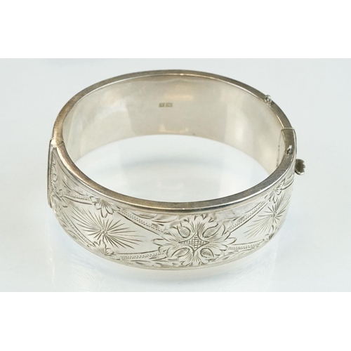 302 - Silver hinged bangle, engraved foliate decoration, tongue and box clasp, width approx 2cm, hallmarke... 