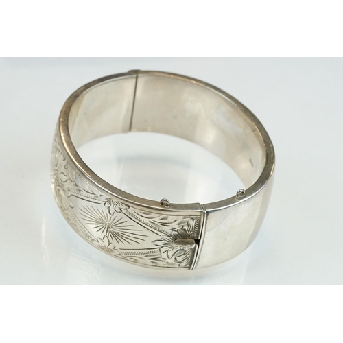 302 - Silver hinged bangle, engraved foliate decoration, tongue and box clasp, width approx 2cm, hallmarke... 