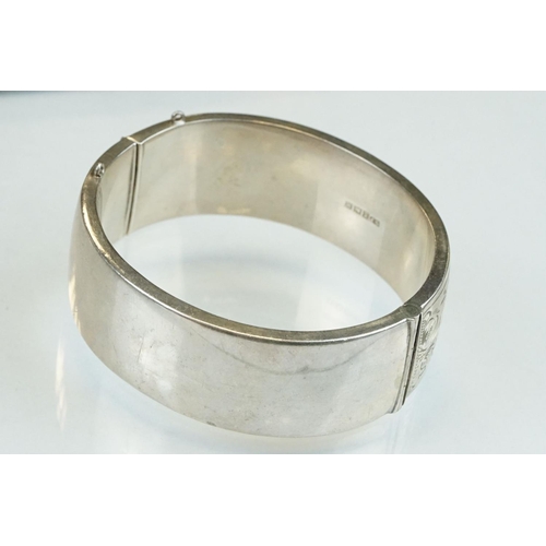 302 - Silver hinged bangle, engraved foliate decoration, tongue and box clasp, width approx 2cm, hallmarke... 