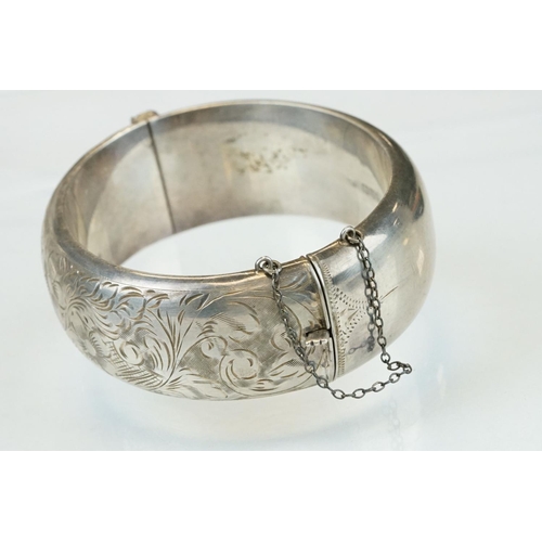 303 - Silver hinged bracelet, engraved floral and foliate decoration to the upper half, tongue and box cla... 