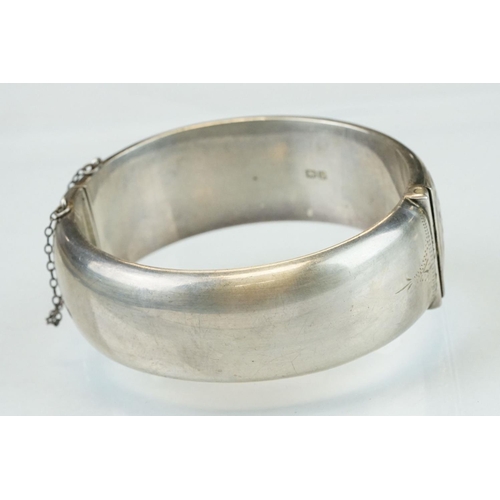 303 - Silver hinged bracelet, engraved floral and foliate decoration to the upper half, tongue and box cla... 