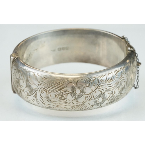 303 - Silver hinged bracelet, engraved floral and foliate decoration to the upper half, tongue and box cla... 