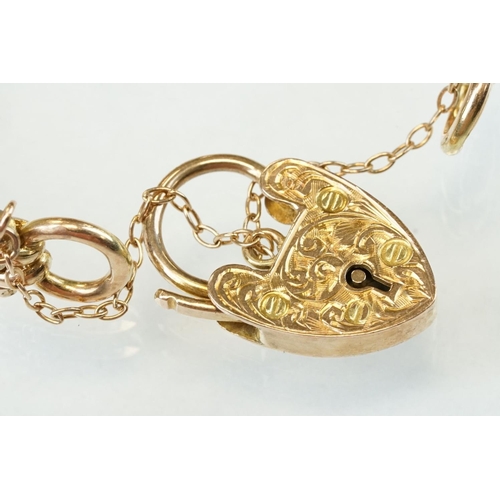 47 - 9ct yellow gold gate link bracelet, heart shaped padlock clasp with foliate scroll decoration, the l... 