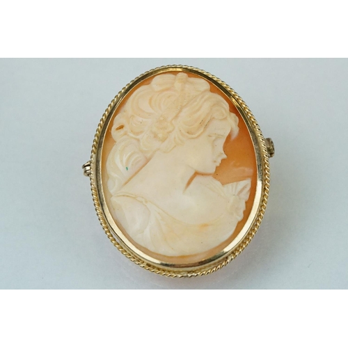 124 - Shell cameo 9ct yellow gold brooch depicting the Three Graces, rubover set, rope twist surround; tog... 