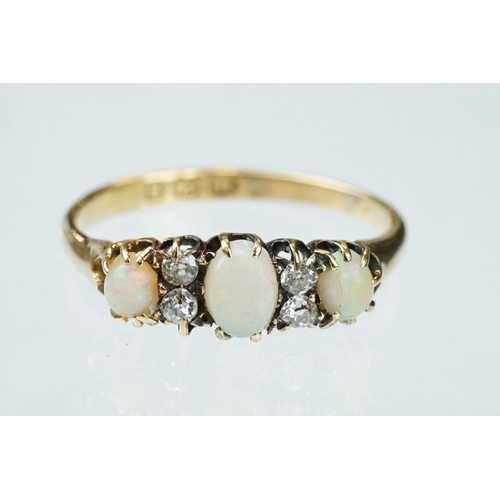 132 - Opal and diamond 18ct yellow gold ring, three graduated oval cabochon cut precious white opals, indi... 