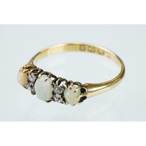 132 - Opal and diamond 18ct yellow gold ring, three graduated oval cabochon cut precious white opals, indi... 