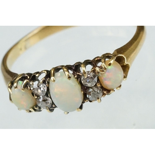 132 - Opal and diamond 18ct yellow gold ring, three graduated oval cabochon cut precious white opals, indi... 