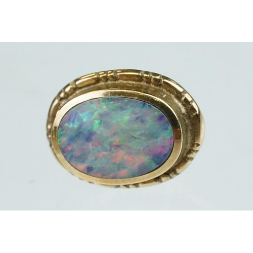 134 - Pair of opal doublet 9ct yellow gold stud earrings, the oval opal displaying indigo, blue, green and... 