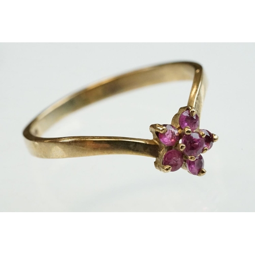 200 - Ruby and diamond 9ct yellow gold ring, crossover style, three graduated round mixed cut rubies, one ... 