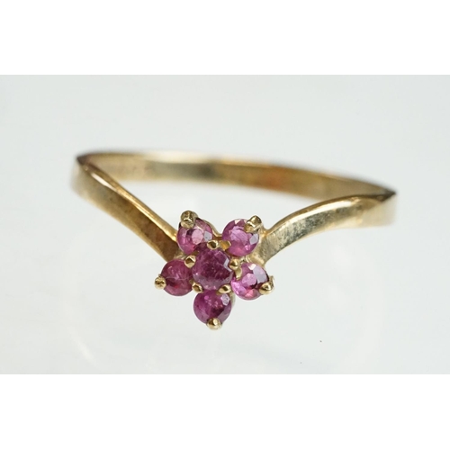 200 - Ruby and diamond 9ct yellow gold ring, crossover style, three graduated round mixed cut rubies, one ... 