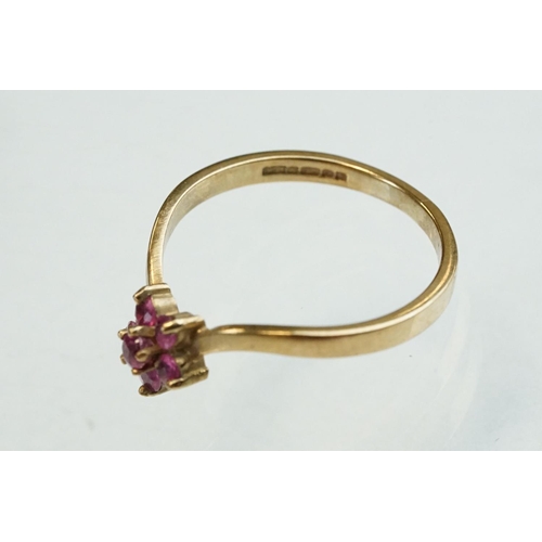 200 - Ruby and diamond 9ct yellow gold ring, crossover style, three graduated round mixed cut rubies, one ... 