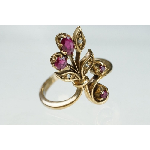 200 - Ruby and diamond 9ct yellow gold ring, crossover style, three graduated round mixed cut rubies, one ... 