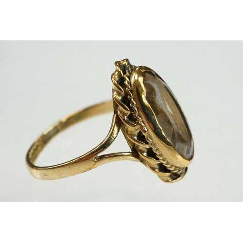 204 - Smoky quartz 9ct yellow gold ring, the oval mixed cut smoky quartz measuring approx 14mm x 6mm, rubo... 