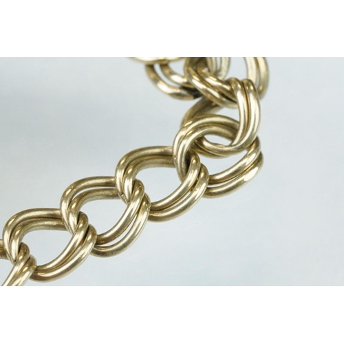 228 - 9ct yellow gold double curb link bracelet, padlock clasp,  with a 9ct gold charm