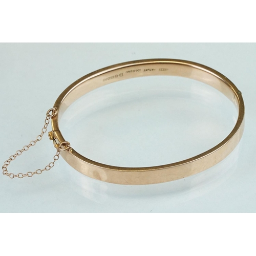 232 - 9ct rose gold hinged bangle, engraved textured design to upper half, the tongue and box clasp with s... 