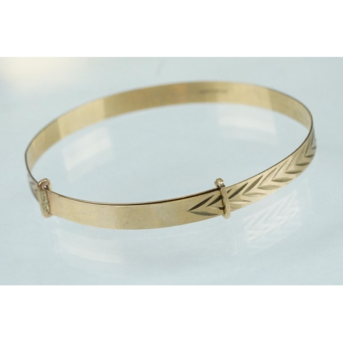 233 - 9ct yellow gold Christening bangle, engraved stylised foliate decoration, width approx 5mm