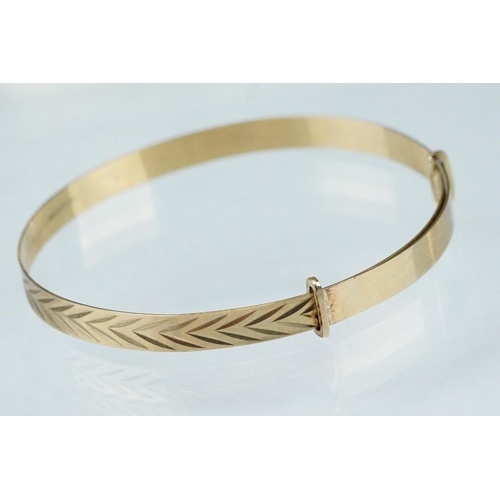 233 - 9ct yellow gold Christening bangle, engraved stylised foliate decoration, width approx 5mm