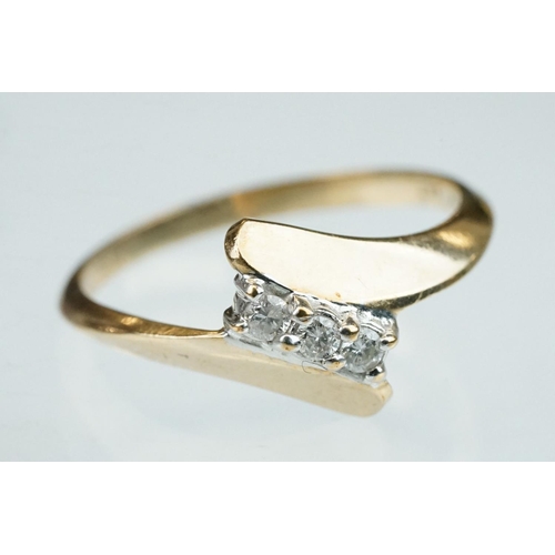 240 - Diamond 10ct yellow gold crossover ring, three small round brilliant cut diamonds, total diamond wei... 