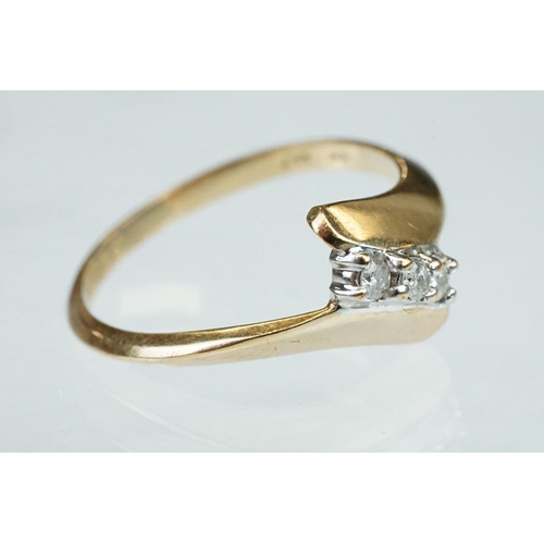 240 - Diamond 10ct yellow gold crossover ring, three small round brilliant cut diamonds, total diamond wei... 