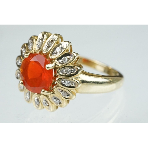 248 - Fire opal and diamond 14ct yellow gold flower head ring, the round mixed cut orange fire opal diamet... 