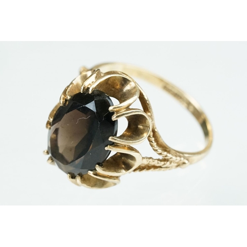 257 - Smoky quartz 9ct yellow gold ring, size Q; rose metal ring of clasped hands, ring size K; and a blue... 