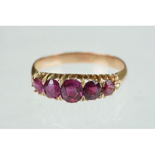 260 - Ruby rose metal ring, five graduated mixed cut rubies, the central ruby measuring approx 5mm x 4mm, ... 