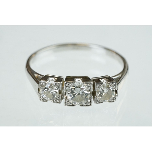 164 - Diamond three stone unmarked white gold ring, three graduated round brilliant cut diamonds, within s... 