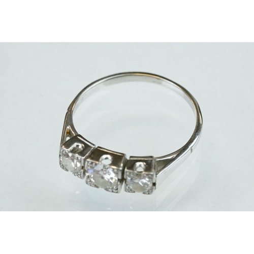 164 - Diamond three stone unmarked white gold ring, three graduated round brilliant cut diamonds, within s... 