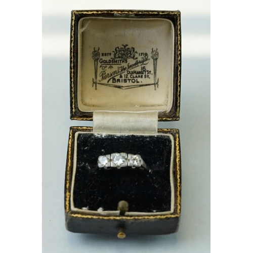 164 - Diamond three stone unmarked white gold ring, three graduated round brilliant cut diamonds, within s... 